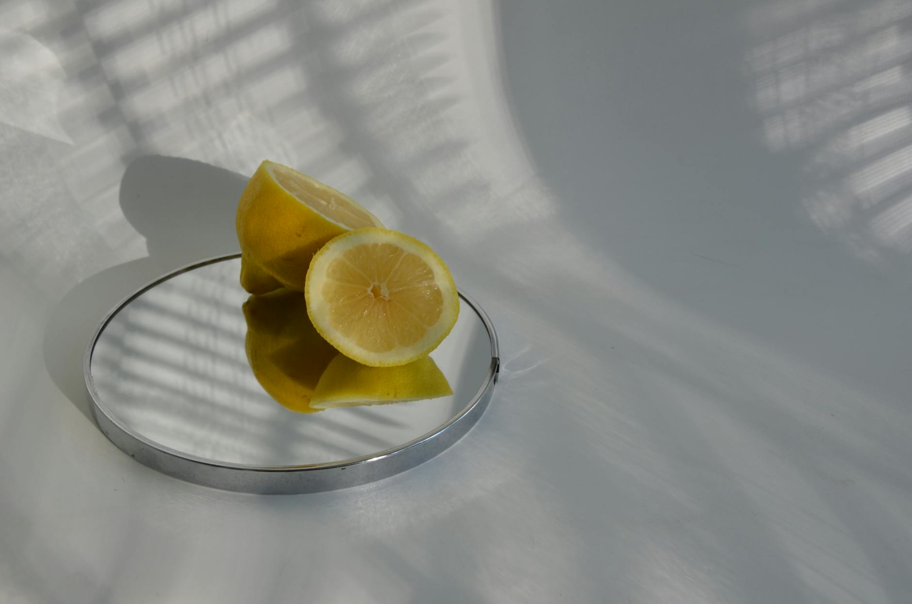 Hand holding a lemon on soft pink background, representing freshness and new beginnings