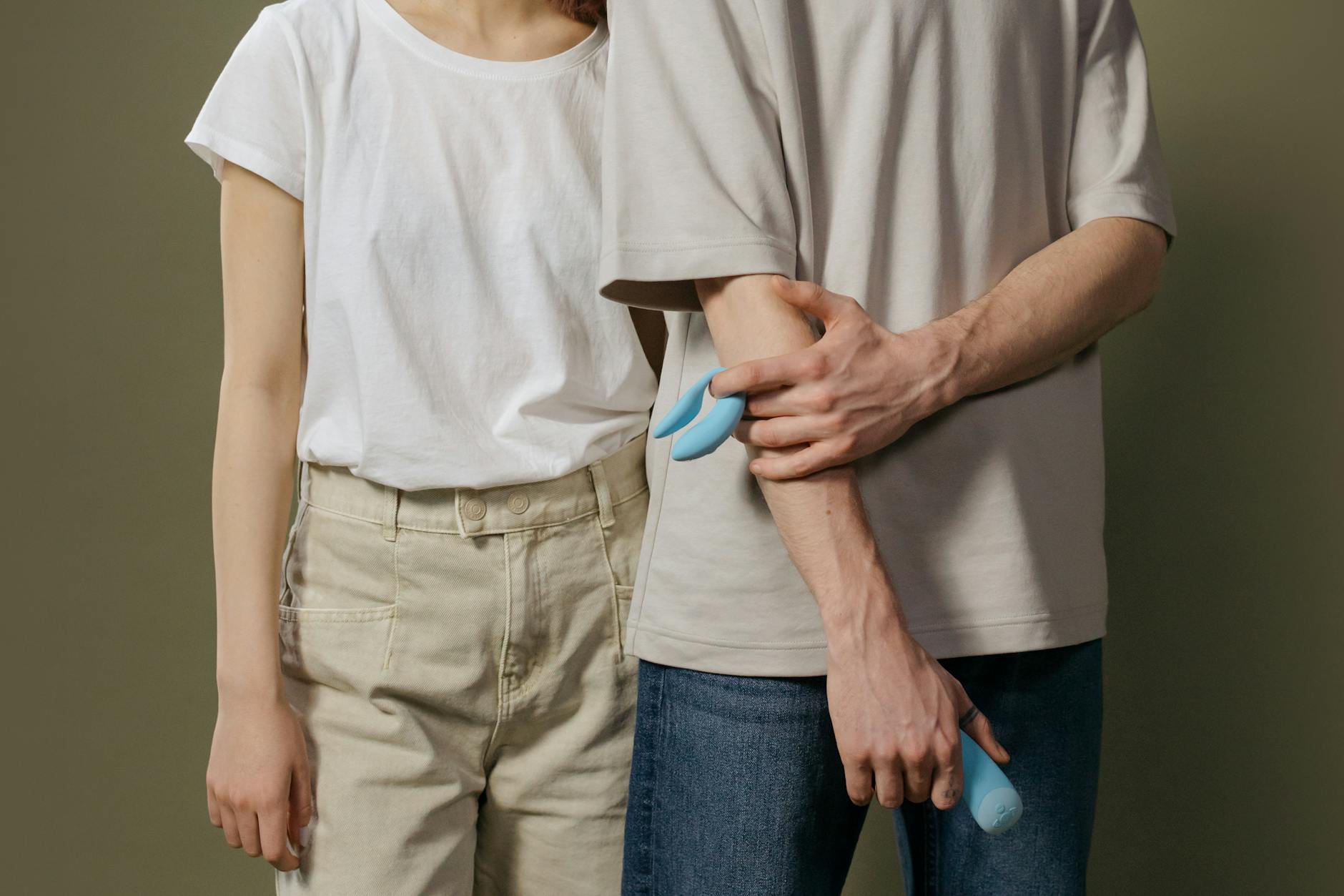A couple exploring intimacy together with a blue vibrator, representing modern connection and pleasure